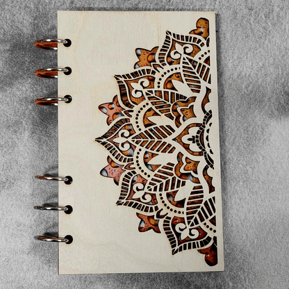 A6 mandala notebook close-up with metal rings and brown ornamental pattern on cover
