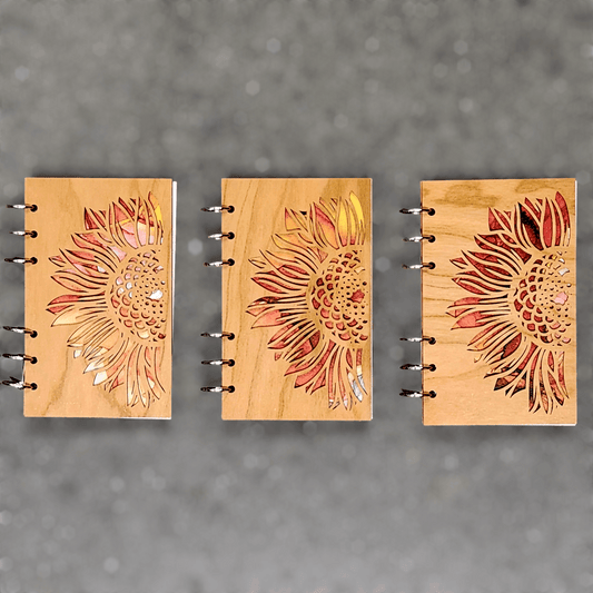 Wood journal notebooks with sunflower laser-cut covers, metal ring binder shown