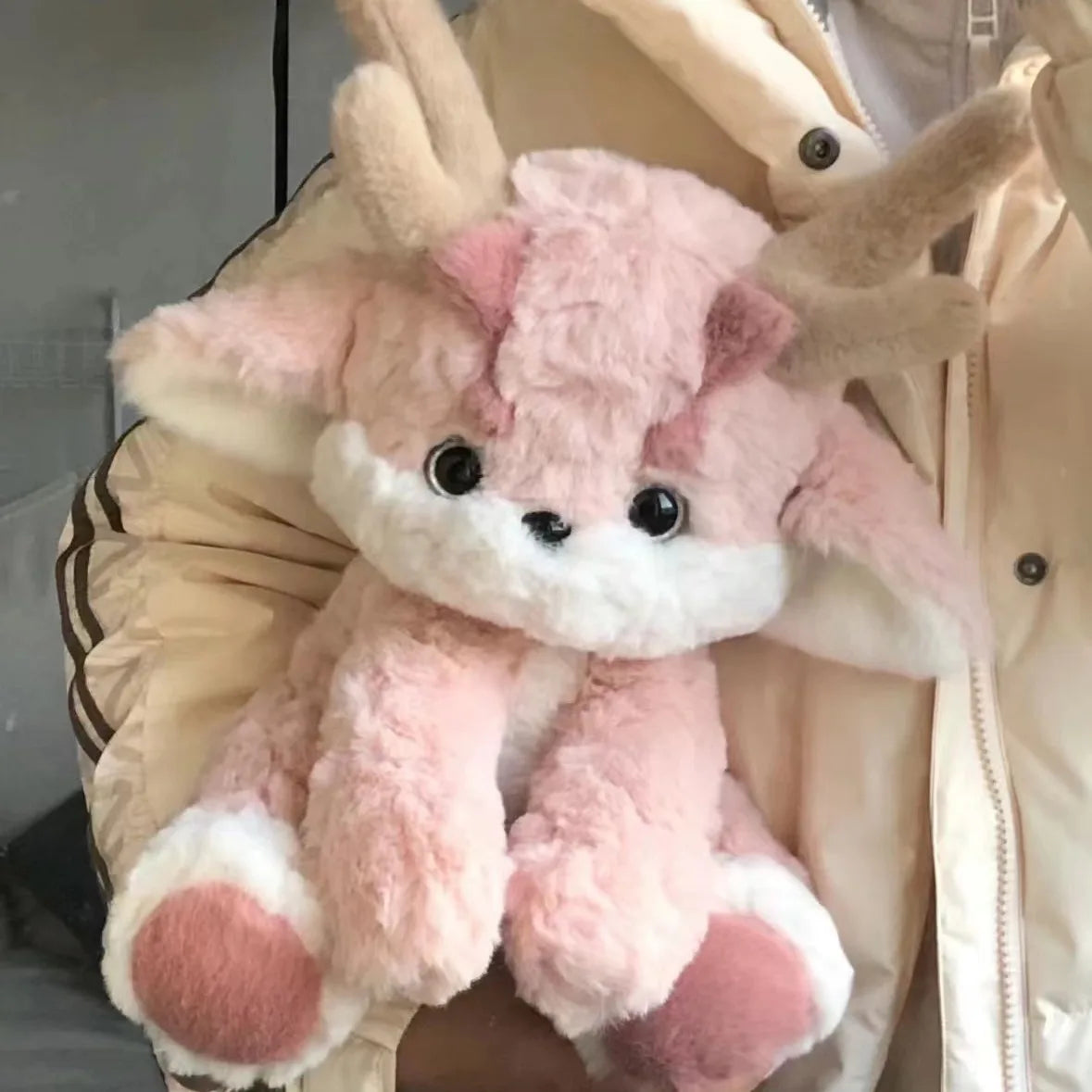 Pink plush dragon with antlers, white muzzle and round black eyes