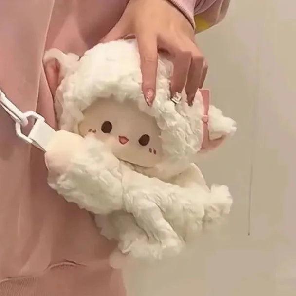 Cream plush lamb crossbody bag with white strap and embroidered face, held by hand