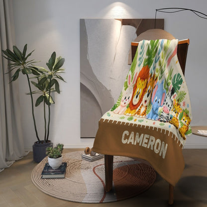 Personalized safari name blanket draped over chair with animal print and CAMERON lettering on brown hem