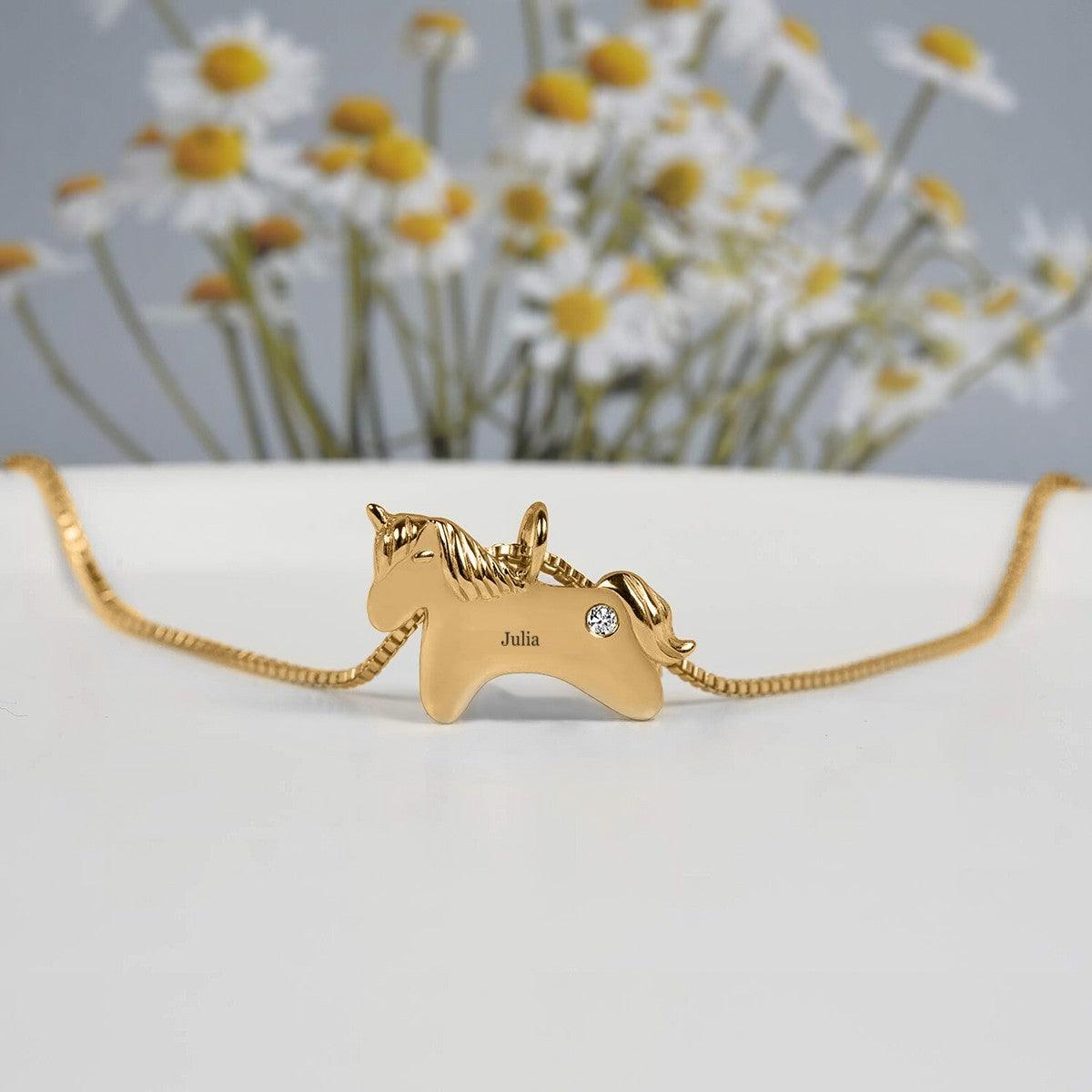 Gold unicorn birthstone necklace with name Julia and a clear round gemstone