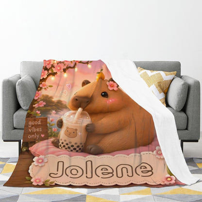 Folded Jolene teddy bear blanket with floral trim shown draped over sofa