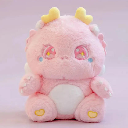 Pink baby dragon plush with star-eye embroidery, yellow horn tips, and heart paws
