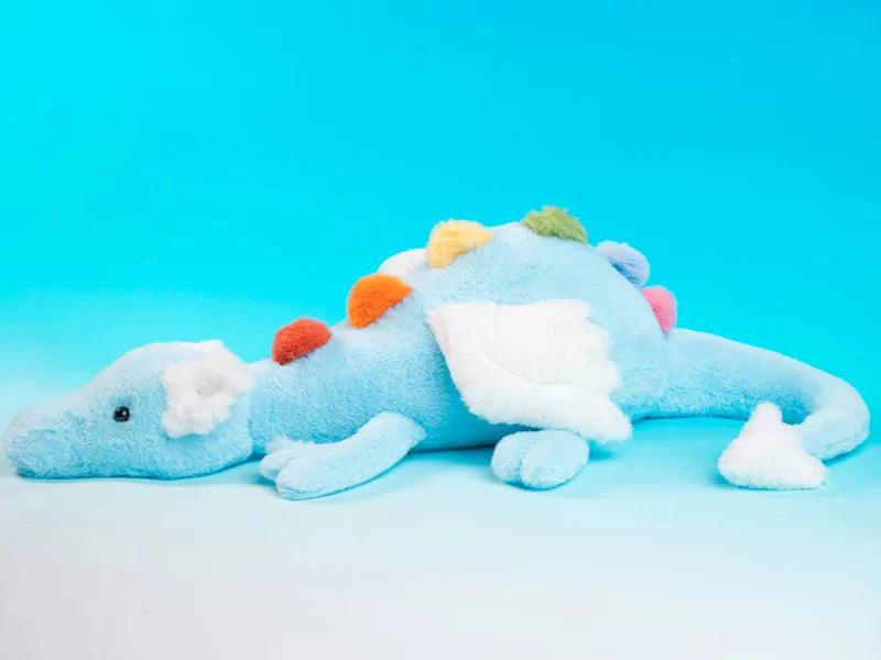 Rainbow dragon plush toy resting pose, light blue with white paws and rainbow pom details