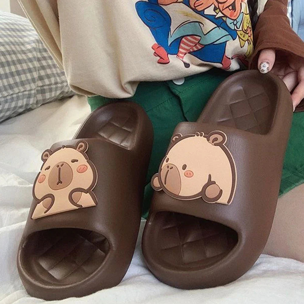 Dark brown capybara slide sandals with cartoon face detail on front strap.