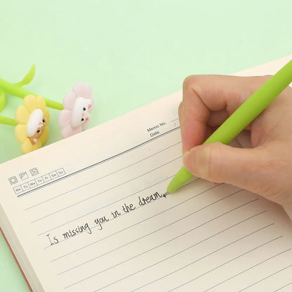 Green animal flower pen held while writing on lined paper