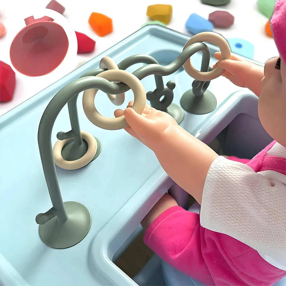 Silicone bead wrap baby learning toy with green arched loops, suction cups, and animal pegs