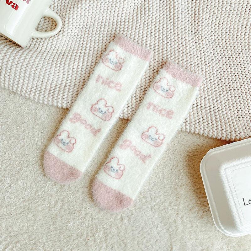 Bunny socks in white with repeating small bunny paw icons and pastel pink accents.