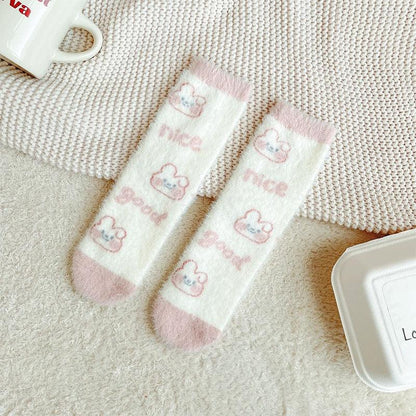 Bunny socks in white with repeating small bunny paw icons and pastel pink accents.