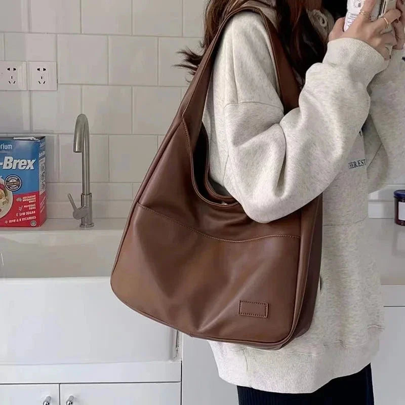 Light brown leather shoulder tote bag with top handles and front patch pocket