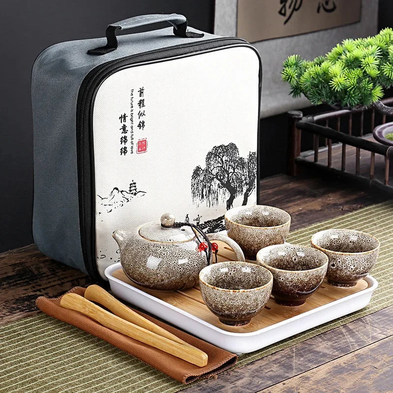 Portable Chinese kung fu tea set in gray carrying bag with speckled teapot and cups on tray