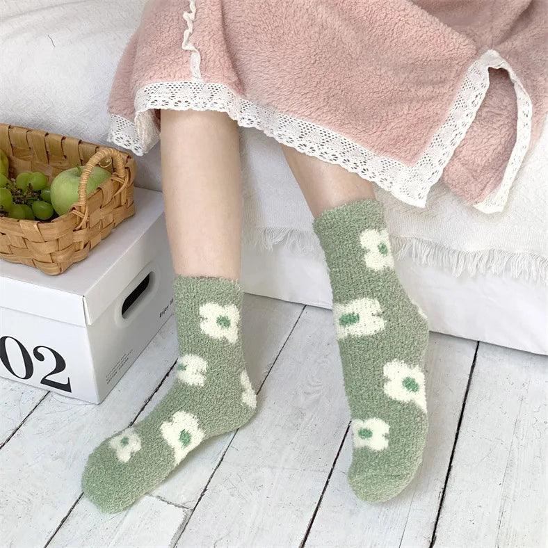 Plush sleeping socks on legs, sage green with white motif and cushioned texture