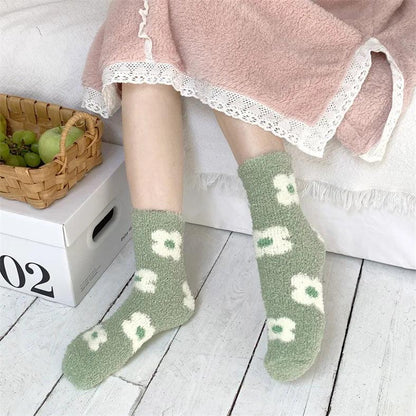 Plush sleeping socks on legs, sage green with white motif and cushioned texture