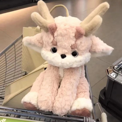Light pink plush dragon with antlers, standing in a cart, white muzzle and black eyes