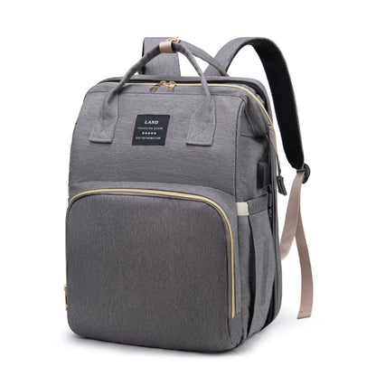Gray diaper backpack front view with padded top handle and side attachment straps