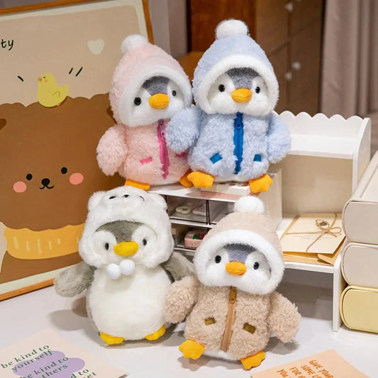 Four plush penguin toys with hooded hats in pastel outfits, stuffed and cute