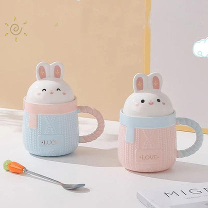 Bunny ceramic mug pair with blue and pink bodies, rabbit lids, and 'LUCK'/'LOVE' text.