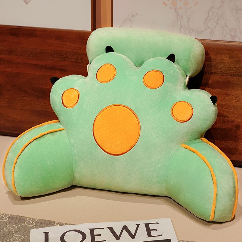 Mint green cat-paw reading pillow with yellow circle face features and curved seams