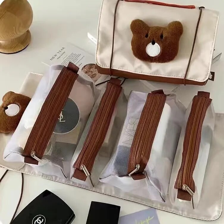 Roll-up makeup bag with bear face patch and four zip pouches, brown zipper straps on white