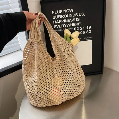 Beige large mesh crochet shoulder bag with long handles, held upright by straps