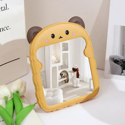 Yellow animal-shaped desktop mirror with brown ears and cartoon cat face