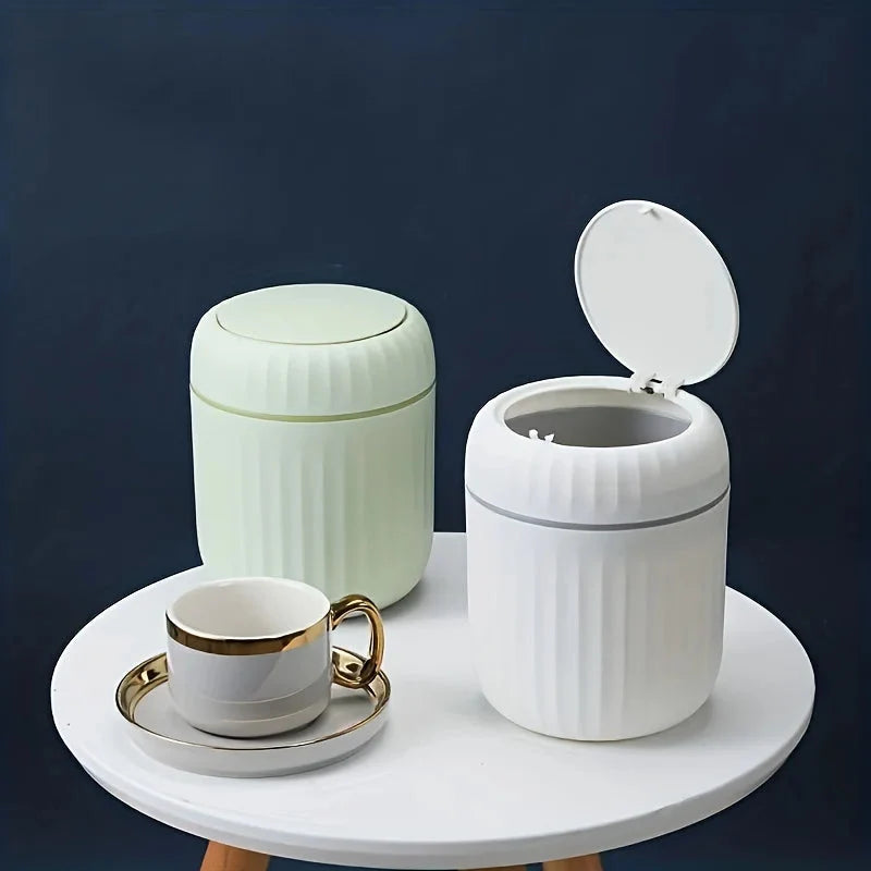 Mini desktop trash can with open lid, ribbed plastic body and gold band, white