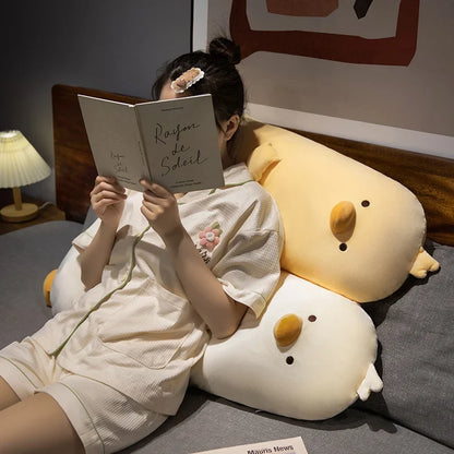 Long chick plush pillows stacked: white and yellow, with rounded bodies and faces