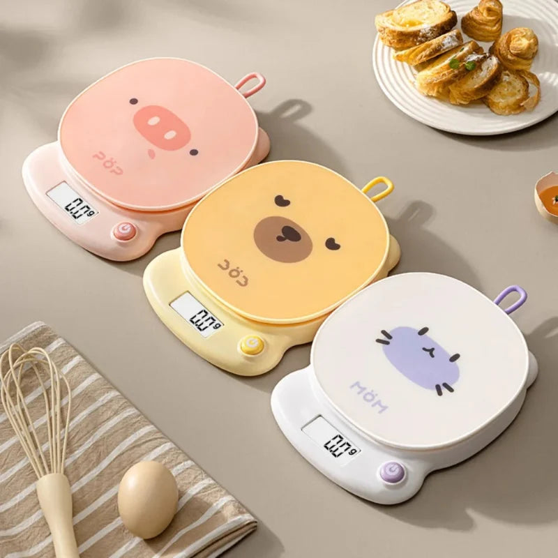 Pink pig-face digital kitchen scale with display and round top handle loop