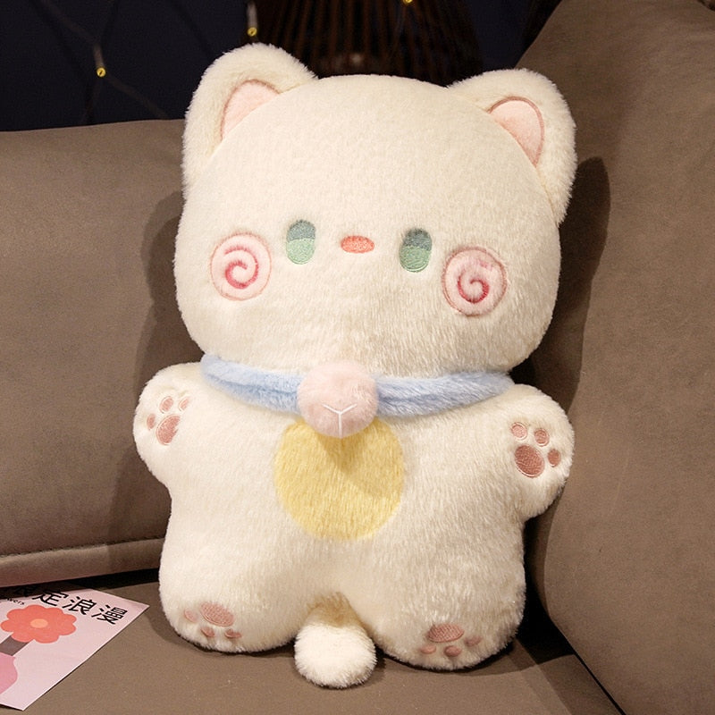 Cream cat-shaped plush pillow with pink swirl cheeks and light-blue neck scarf