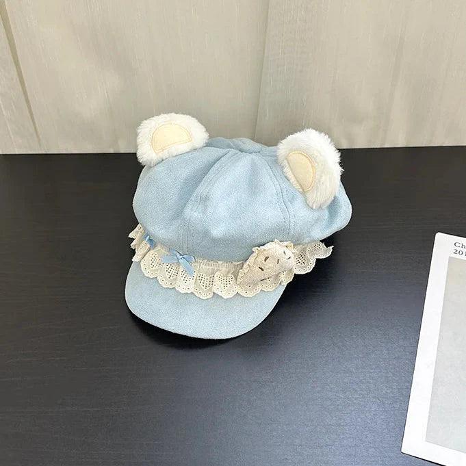 Blue bear cap with white lace trim and teddy-style bear patch