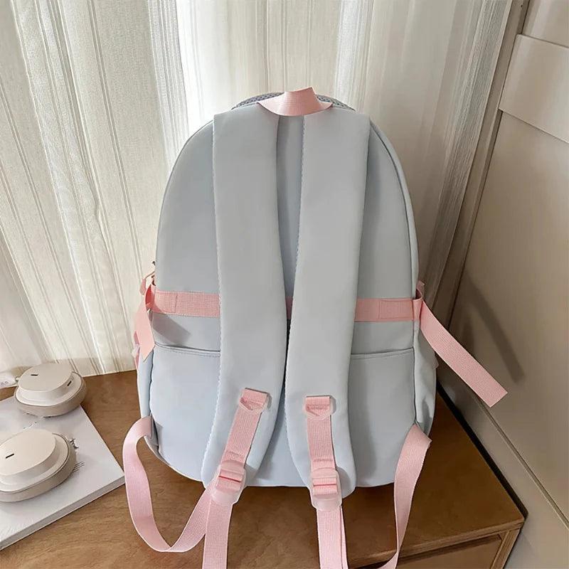 Pastel backpack with padded back, top handle loop, and adjustable shoulder straps