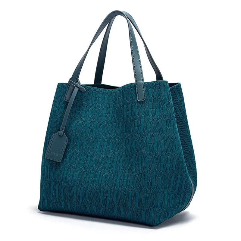 Teal knitted tote bag with embossed CHCH pattern, dual top handles, hanging tag.