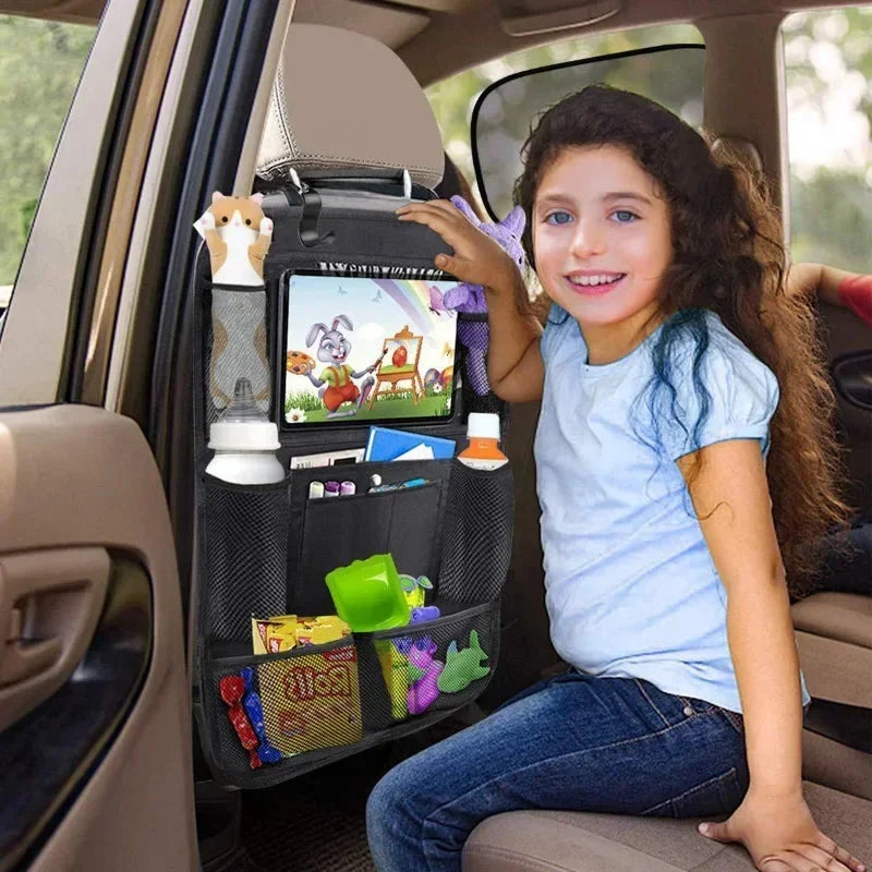 Black car seat organizer with front tablet screen and mesh pockets; child holding tablet.