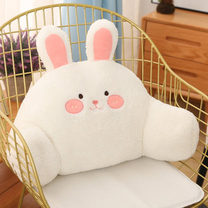 Plush white bunny cushion with pink cheeks and long upright ears in a chair.