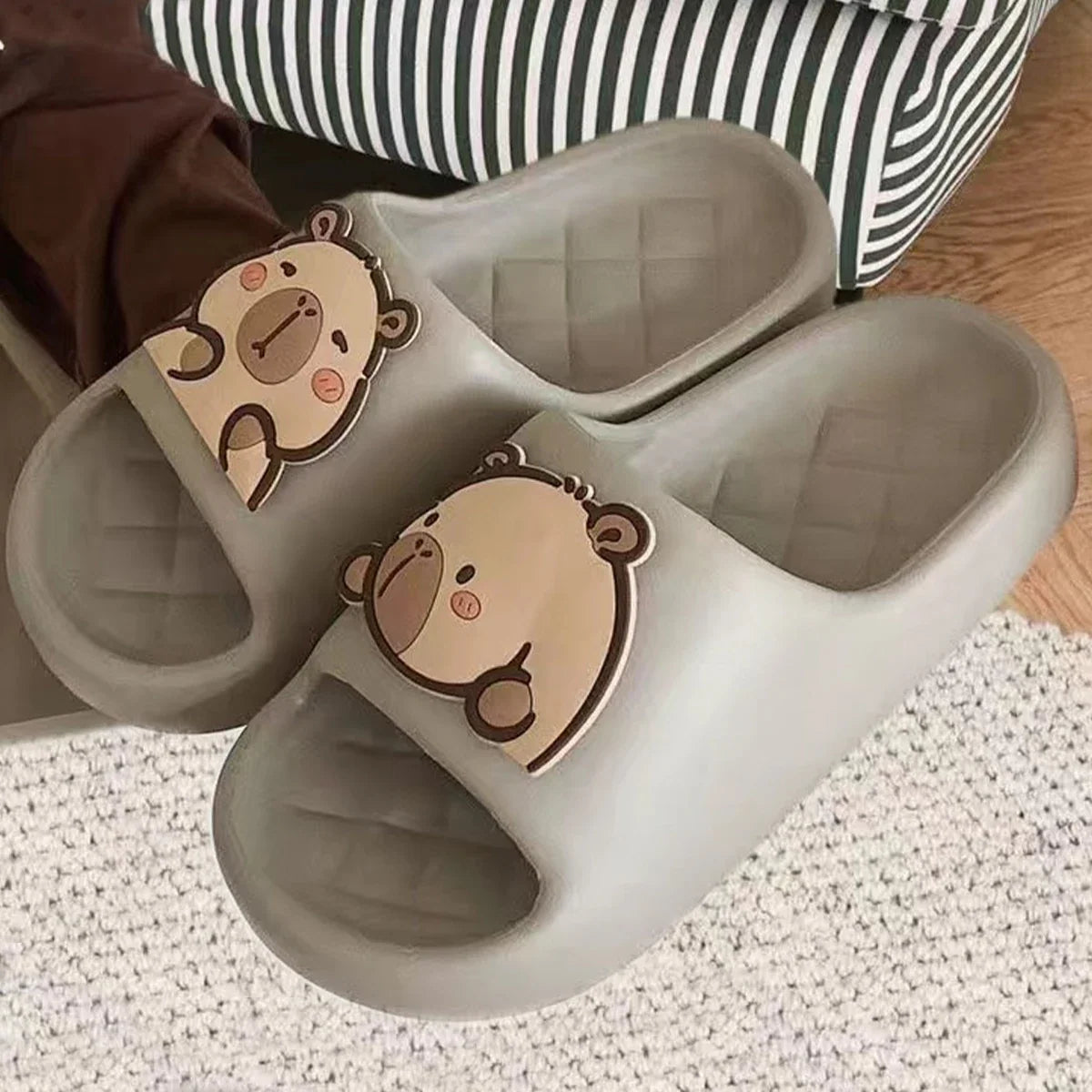 Light gray capybara slide sandals with brown cartoon face on front strap.