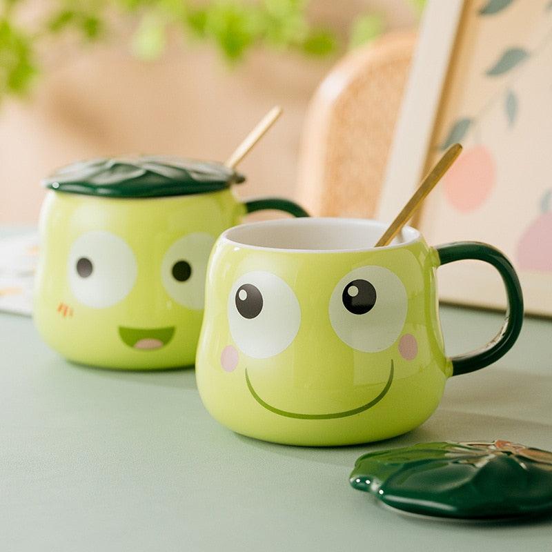 Frog-shaped mug with lid and spoon, lime green body and green handles, smiling face