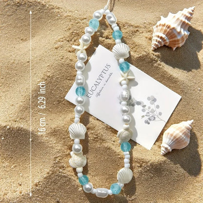 Pearl and blue bead phone charm bracelet with shells and starfish, shown on card
