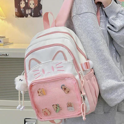 Pink and white cat-face school backpack worn on shoulder with hanging pom keychain