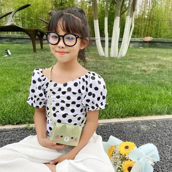 Green bunny crossbody bag on a child, with stitched face and adjustable strap