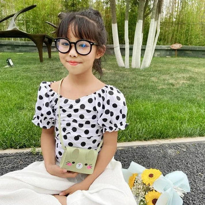 Green bunny crossbody bag on a child, with stitched face and adjustable strap