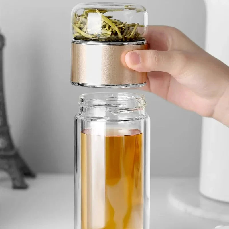 Transparent storage bottle with silver and rose-gold bands, topped with herbs