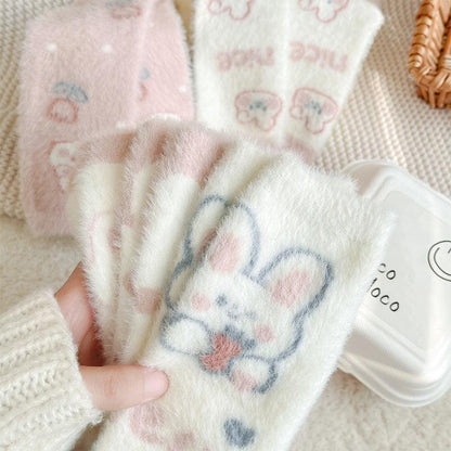 Bunny socks in white with blue and pink heart-and-paw print design, fuzzy knit texture.