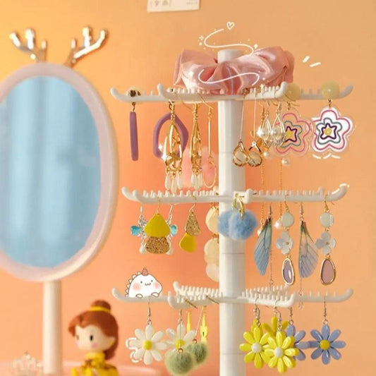 White rotating earring display stand with four tiers and hanging earring accessories