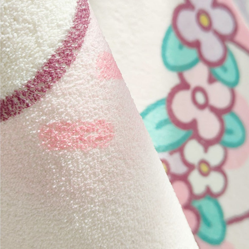 Close-up of plush area rug texture with pink glitter-like stitched accents