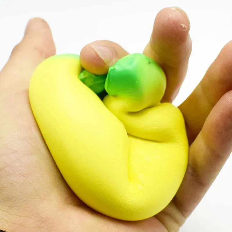 Jumbo squishy banana toy squeezed in a hand, yellow with green end