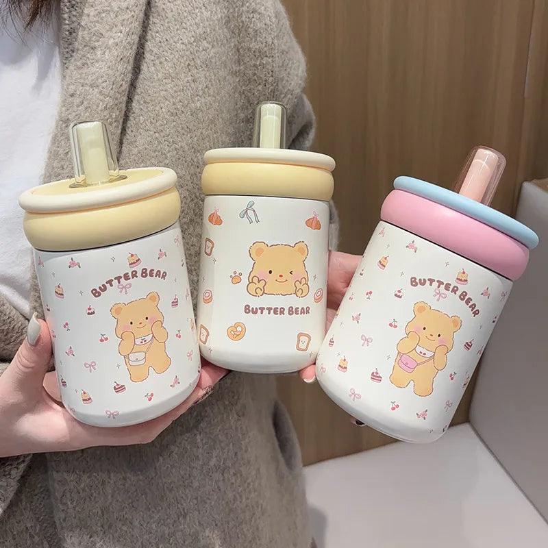 Three Butter Bear thermos cups with cream, yellow, and pink/blue lids, white bear prints