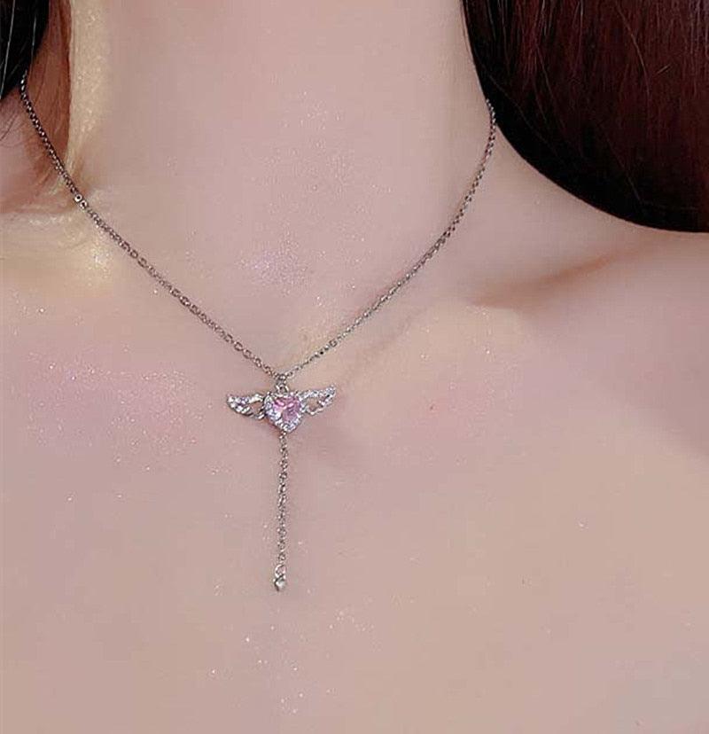 Silver-tone heart-and-wing pendant necklace with pink crystal center
