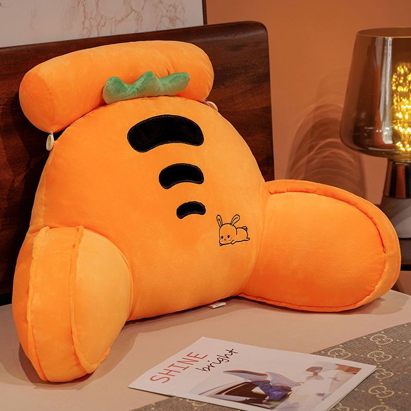 Orange plush character reading pillow with smiling face and small insect graphic