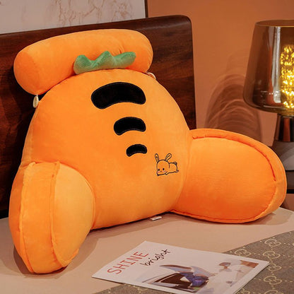 Orange plush character reading pillow with smiling face and small insect graphic
